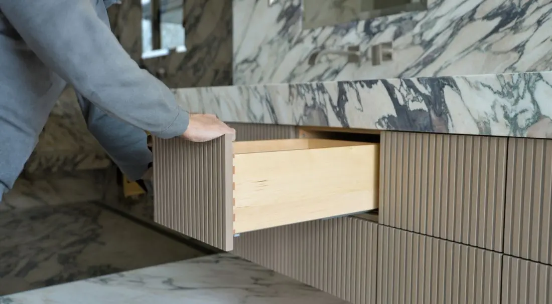 Custom bathroom drawer installation by Homestead Woodworks, showcasing professional craftsmanship and quality finishing in a luxurious marble bathroom.